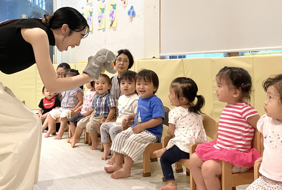 楽しそうにリトミックのレッスンをする講師と子どもの写真