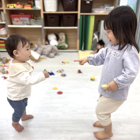 お姉さんと楽しそうに遊ぶ0歳児の写真